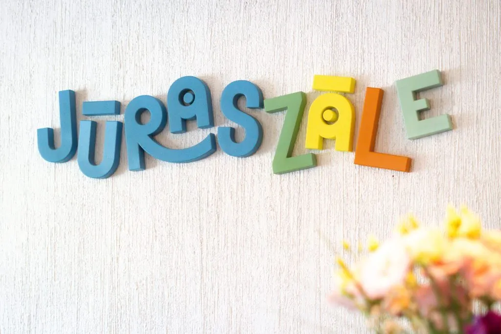 Krāsaini koka burti "JūrasZāle" uz sienas